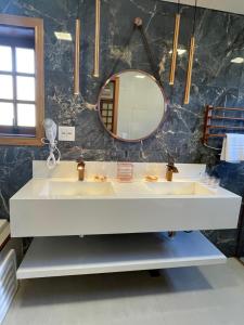 a bathroom with two sinks and a mirror at Pousada Monte Silvestre in Monte Verde