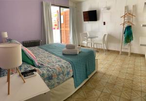 a bedroom with a bed and a table with chairs at POSADA DEL CENTRO in Villa General Belgrano