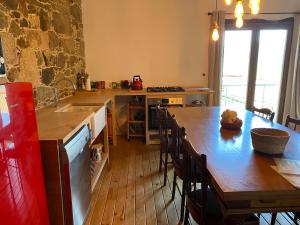 a kitchen with a wooden table and a wooden floor at Farm house in Ribeira Sacra in O Carballo +26 photos