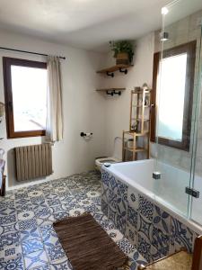 un bagno con vasca e un pavimento con piastrelle bianche e blu di Farm house in Ribeira Sacra a O Carballo