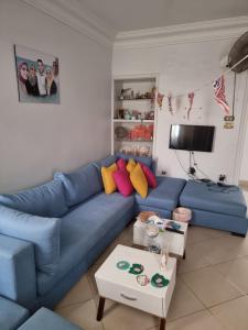 een woonkamer met een blauwe bank en een tafel bij "sara accommodation room "no Egyptians "Dormitory room in Caïro