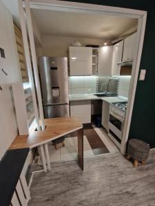 a kitchen with a wooden table and a refrigerator at Leśny Kącik tuż przy centrum miasta in Krosno