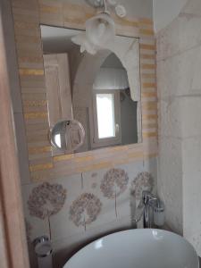 een badkamer met een wastafel en een spiegel bij ROSSINI GUEST HOUSE in Martina Franca