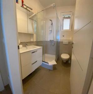 uma casa de banho com um chuveiro, um WC e um lavatório. em Villa Pergola -Apartment Roko em Mlini