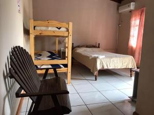 Habitación con litera y silla en Apart Clavel del Aire en Puerto Iguazú