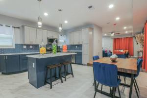 a kitchen and dining room with a table and blue chairs at Vibrant Island Home - 3 Bedrooms and 2 Bathrooms in Atlantic City