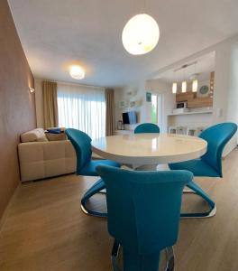 uma sala de estar com uma mesa e cadeiras azuis em Villa Pergola -Apartment Roko em Mlini