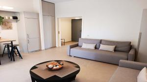 een woonkamer met een bank en een tafel bij Hanioti Beach Front Apartments in Hanioti