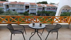 a table and two chairs on a balcony with buildings at Hanioti Beach Front Apartments in Hanioti