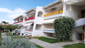 a white building with balconies on the side of it at Hanioti Beach Front Apartments in Hanioti +39 photos