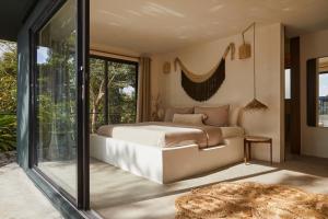 ein Schlafzimmer mit einem Bett und einem großen Fenster in der Unterkunft SELVA by DW in Fajardo