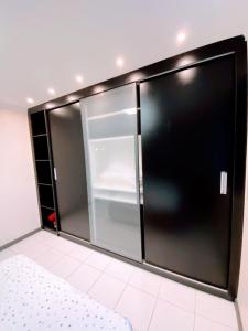 een glazen koelkast in een kamer met een witte vloer bij Apartamento completo - Jatiúca - Perto de tudo in Maceió