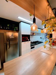 een keuken met een houten aanrecht en een koelkast bij Apartamento completo - Jatiúca - Perto de tudo in Maceió