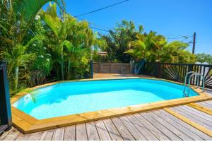 a swimming pool on a deck with a wooden floor and a wooden deck at Sunshine Villa in Le Moule