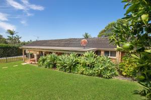 une maison avec une pelouse devant elle dans l'établissement Kelvin Grove 1, à Port Macquarie