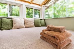 a room with a bed with a pile of towels at PonoMana Oasis's - Koi Cottage in Captain Cook