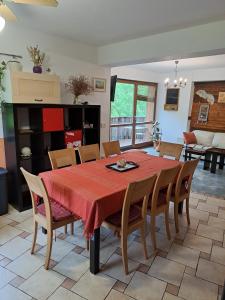 a dining room with a red table and chairs at Family House in Mozirje