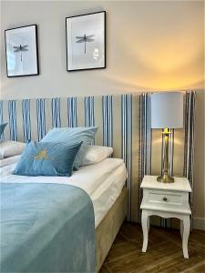- une chambre avec un lit et une table avec une lampe dans l'établissement Apartamenty Kamienica Arte 4, à Ustka