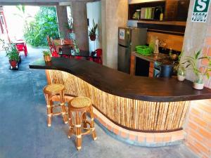 a bar with stools in a room with a counter and a kitchen at Hospedaje Neydita in Iquitos