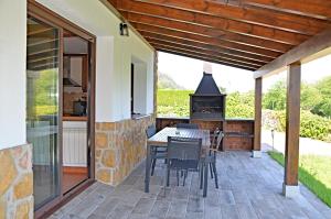 an outdoor patio with a table and a stove at Villa La Atalaya in Llanes