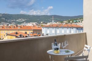 una mesa en un balcón con vistas a la ciudad en Maison D'Or, en Trieste