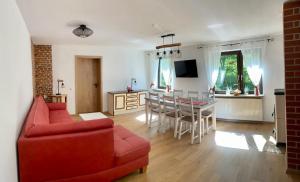 - un salon avec un canapé rouge et une table dans l'établissement Ferienhaus Mariental, à Rudolstadt