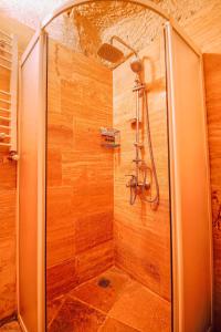 a shower with a glass door in a bathroom at Alaca Cave Suites in Goreme