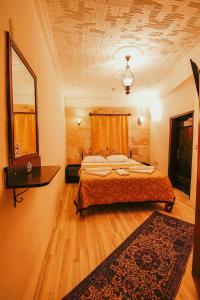 a bedroom with a large bed and a rug at Alaca Cave Suites in Goreme