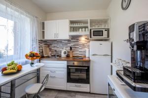 a kitchen with white cabinets and a white refrigerator at Elendris - Ubytování u kostela in Brno