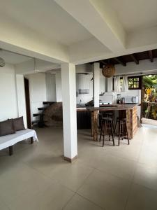 a kitchen and living room with a couch and a table at Cabanas Alto Mar in Praia do Rosa