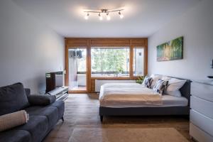 a living room with a bed and a couch at Auszeit Apartment BLACK FOREST EMOTION mit Sonnenbalkon mit Blick auf den Kurpark, schnelles Internet, Nähe Triberger Wasserfälle, für bis zu 2 Personen in Schönwald