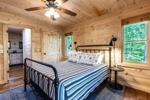 Schlafzimmer mit einem Bett und einem Deckenventilator in der Unterkunft Luxe Family Cabin 8 min to Downtown Blue Ridge in Blue Ridge