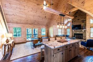 eine Küche und ein Wohnzimmer in einem Blockhaus in der Unterkunft Luxe Family Cabin 8 min to Downtown Blue Ridge in Blue Ridge
