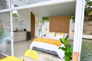 a bedroom with a large bed and a balcony at Casa Flotante La Trinidad in Guatapé