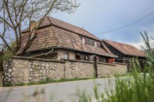 an old house with a stone wall next to a street at LaConac Lupsa in Lupşa