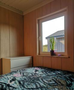 um quarto com uma cama e uma janela em Atostogu nameliai prie Palangos 