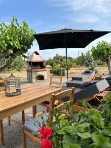 a picnic table with a black umbrella and chairs at Aegean Endless Summer Villa Pefkos in Pefki Rhodes