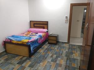- une chambre avec un lit, une commode et une porte dans l'établissement Aswan Hotel Appartments, à Assouan