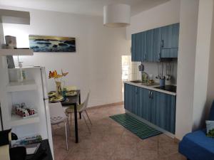 una cucina con armadi blu e un tavolo in una stanza di San Teodoro a San Teodoro