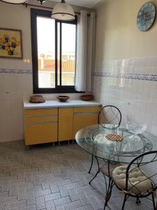 アジャクシオにあるAppartement Ajaccio vue merのキッチン(ガラステーブル、椅子2脚付)