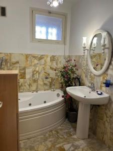 a bathroom with a tub and a sink and a mirror at Appartement Ajaccio vue mer in Ajaccio