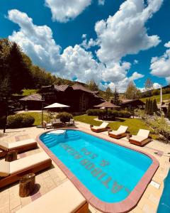 einen Pool mit Liegestühlen und ein Haus in der Unterkunft Zlatibor Resort & Spa in Zlatibor