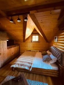 ein Schlafzimmer mit einem Bett in einer Holzhütte in der Unterkunft Zlatibor Resort & Spa in Zlatibor