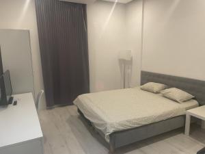 1 dormitorio con 1 cama y TV en Micadas Apartamenty en Piaseczno