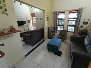 una sala de estar con 2 sofás y un taburete azul en Hostel do Gui en Alto Paraíso de Goiás