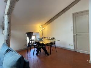 ein Esszimmer mit einem Tisch, Stühlen und einem Sofa in der Unterkunft Appartement de charme au cœur d'Avignon in Avignon