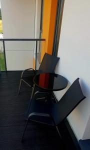 a chair and a table with a laptop on it at Deluxe apartments - self check in in Klaipėda +1 photo