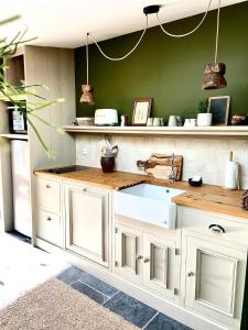 a kitchen with white cabinets and a sink at Un matin de mai, Côte d'Opale in Verlincthun