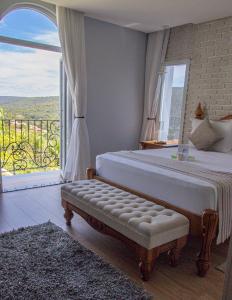 um quarto com uma cama e uma grande janela em Vila Pugliesi Hotel Boutique em Lençóis