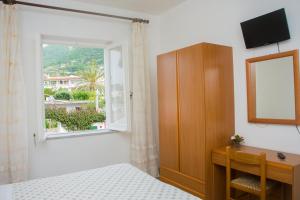 um quarto com uma cama, uma janela e uma secretária em Hotel Villa Mena em Ischia